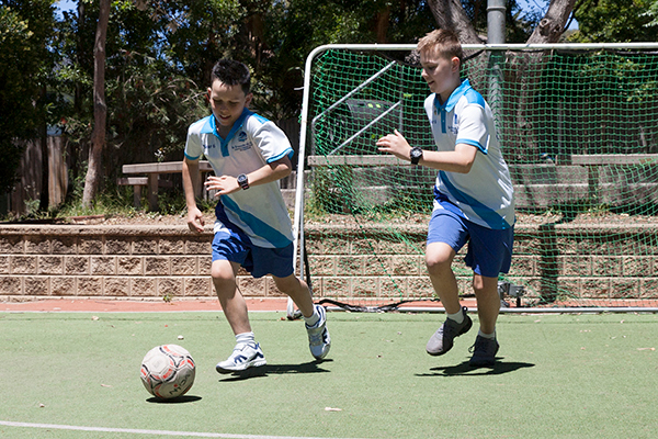 St Francis de Sales Catholic Primary School Woolooware Co-curricular Sport Two students racing towards soccer ball