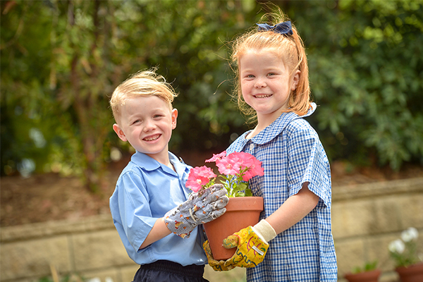 St Francis de Sales Catholic Primary School Woolooware Student Wellbeing Two students holding a flower pot and smiling